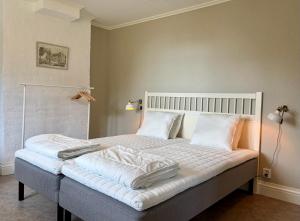 a bedroom with a bed with white sheets and pillows at Boende i Sandarne in Sandarne