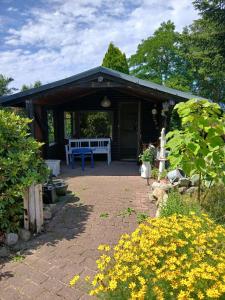 a pavilion with a blue bench in a garden at Ferienwohnung Lenhardt in Barkenholm