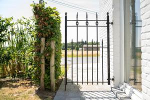 an iron gate with ivy on a white house at 't Boshuisje in Poperinge