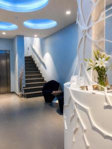 a lobby with blue walls and stairs with a vase of flowers at Hotel Boutique La Mar - Adults Only in Peniscola +54 photos