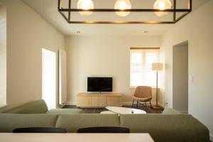 a living room with a couch and a television at 't Boshuisje in Poperinge +45 photos