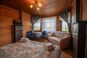 a bedroom with a bed and a couch in a room at Gościniec Lila in Mikołajki