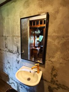a bathroom sink with a mirror on a wall at Zen Tree House in Silebeng +8 photos