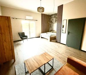 a living room with a table and a bed at Pełnia Mazur in Pasym