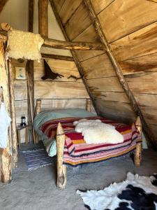 a bed in a cabin with a wooden ceiling at les portes de l'histoire in Pleine-Fougères