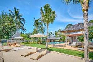 a villa with a swimming pool and palm trees at Villa Ayundra in Lipa Noi
