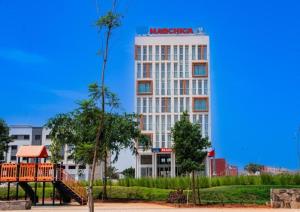 a hotel with a playground in front of a building at Marchica Hotel in Nador