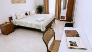 a bedroom with a bed and a table and a table and chair at Gypsy Walker in Varkala +14 photos