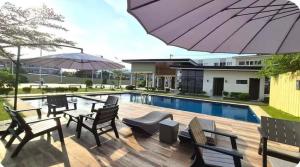 a patio with chairs and tables next to a swimming pool at Yangʻs HoMeey Place in Bankal