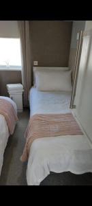 a hotel room with two beds and a window at Craig Tara Beach Lodge in Ayr