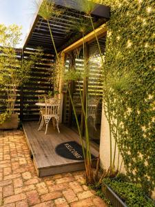 a patio with a table and chairs in a garden at Art-Inspired Bedroom Close to CBD in Mossel Bay