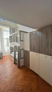an empty room with a kitchen and a room with wooden floors at BakuDowntownHostel in Baku