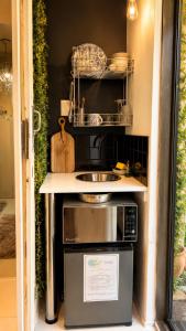 a small kitchen with a sink and a microwave at Art-Inspired Bedroom Close to CBD in Mossel Bay