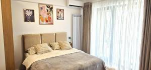 a bedroom with a bed and a large window at Studio S23 in Piatra Neamţ
