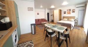 a small room with a bed and a table and chairs at Studio S23 in Piatra Neamţ