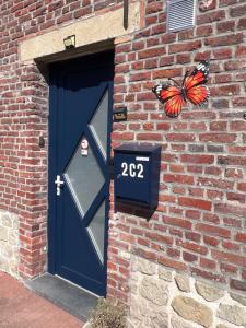 a butterfly is sitting on the door of a brick building at Résidence du Moulin 2-C Proche de Pairi Daiza - Parking Gratuit in Boussu