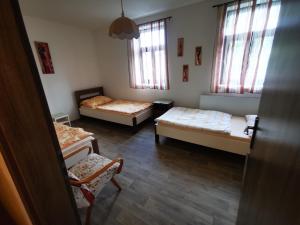 a room with three beds and two chairs and windows at Farma Dolní Dvořiště in Dolní Dvořiště