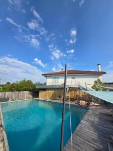 a house with a swimming pool and a wooden deck at La Villa Belle in Biscarrosse