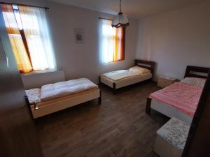 a room with three beds and two windows at Farma Dolní Dvořiště in Dolní Dvořiště
