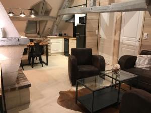 een woonkamer met 2 stoelen en een glazen tafel bij L'envie d'ailleurs in Honfleur