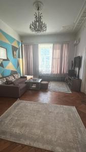 a living room with a couch and a chandelier at BakuDowntownHostel in Baku