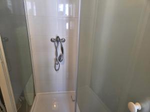 a shower stall with a glass door with a shower at Le Petit Attique de Versailles in Versailles