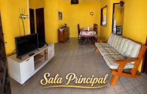 a living room with a couch and a tv at Paracuru Praia in Paracuru