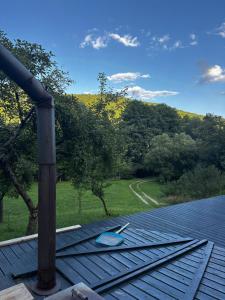 a deck with a view of a field and trees at Cabana La Poiata in Valea Chioarului