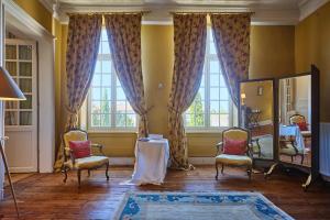 a room with two chairs and a table and windows at Maison d'hôtes de charme Le Clos de la Cathédrale en Sud Gironde in Bazas