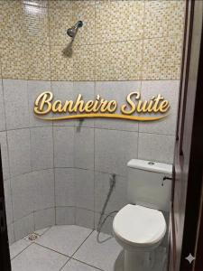 a bathroom with a toilet and a sign on the wall at Paracuru Praia in Paracuru