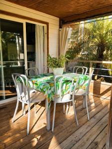 a table and chairs on a porch with a table and chairs at Au Paradis de Peggy - Bungalow 5 pers - Village de la Pointe Faula in Le Vauclin