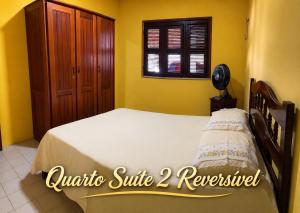 a bedroom with a bed in a yellow room at Paracuru Praia in Paracuru