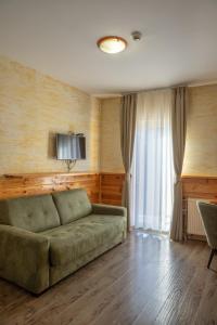ein Wohnzimmer mit Sofa und Fernseher in der Unterkunft Hotel Enigma in Žabljak