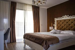a bedroom with a large bed and a window at Cataleya House in Oeşti-Pămînteni