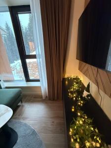 a living room with a christmas tree on a fireplace at SkyHill Jahorina Gondola Poljice Newly Opened in Jahorina
