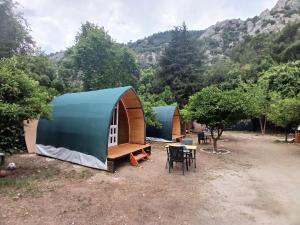 a group of tents with a table and chairs at Kalinka pansiyon in Cıralı