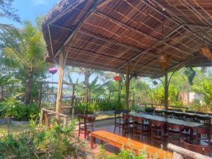 a restaurant with a table and chairs under a roof at Family Room in Tam Kỳ