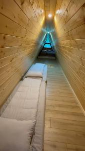 a bed in a room with a wooden wall at Cabana La Poiata in Valea Chioarului +12 photos