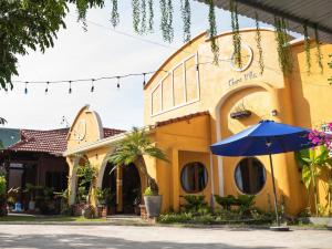 a yellow building with a blue umbrella in front of it at Family Room in Tam Kỳ +11 photos