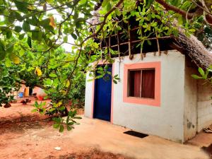 a small house with a blue and red door at Nature Nest In in Auroville +17 photos