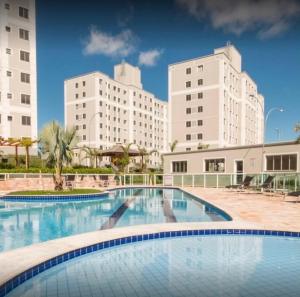 a large swimming pool with two tall buildings in the background at Cantinho aconchegante in Londrina