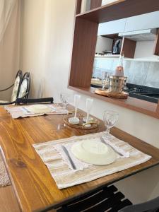 a table with a plate and wine glasses on it at Cantinho aconchegante in Londrina
