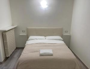 a white bed with a white towel on top of it at Moderno Bilocale Bresso in Bresso