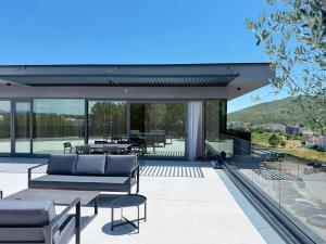 an outdoor patio with furniture and tables and glass doors at Hotel Leone in Međugorje