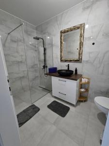 a bathroom with a sink and a shower with a mirror at Mare Ann in Ljubuški +18 photos