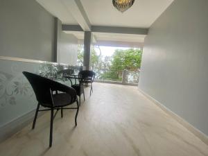 a dining room with chairs and a table and a balcony at Stayat77 in Karsiyang