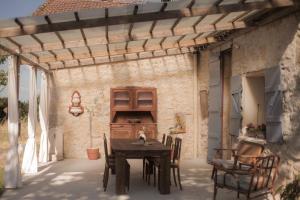 a patio with a table and chairs under a pergola at Maison sur Coline in Lectoure