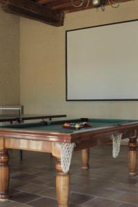 a pool table in a room with a screen at Maison sur Coline in Lectoure