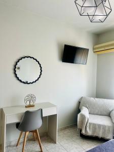 a room with a desk and a chair and a mirror at Armonia Apartments in Archangelos