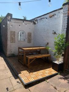 a wooden table and bench sitting on a patio at Spacious Victorian Birkdale Apartment with Garden in Southport